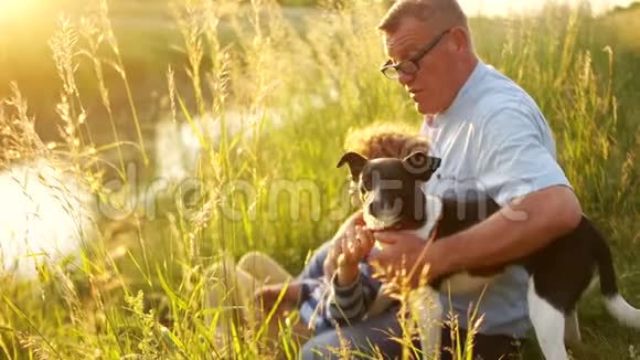 家庭世代交流和人的概念祖父和孙子与他的狗坐在一起交谈视频的预览图