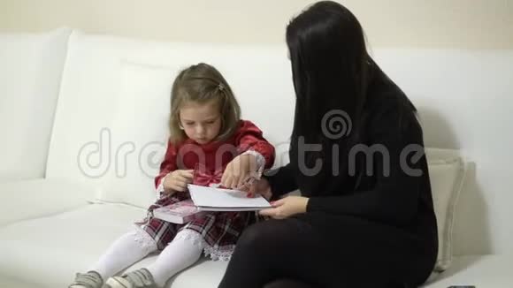 母亲和小女儿看着贴有贴纸的书视频的预览图