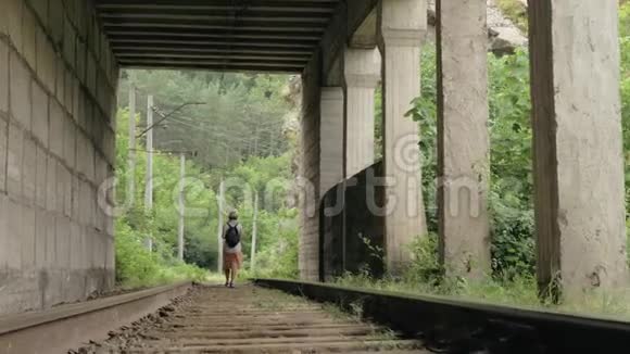 小女孩走在隧道里的铁轨上视频的预览图