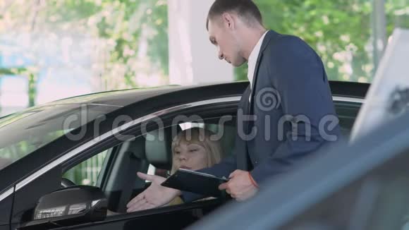 售货员向车厢里的妇女讲述汽车的特性视频的预览图