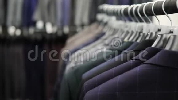 衣架与男士不同颜色的衣服背景的西装店特写视频的预览图