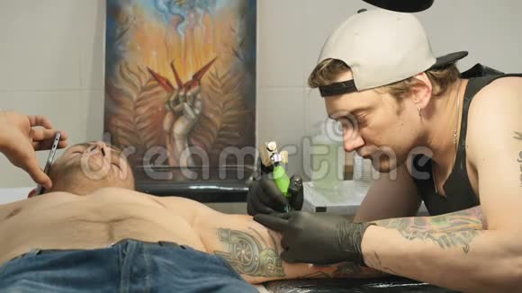 专业纹身师正在纹身沙龙人手上做纹身视频的预览图
