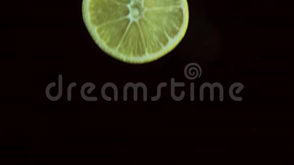 圆形的新鲜多汁的柠檬片投入透明的水中惊人的飞溅打破了表面视频的预览图