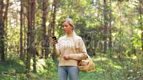 有蘑菇的女人在树林里打电话视频的预览图