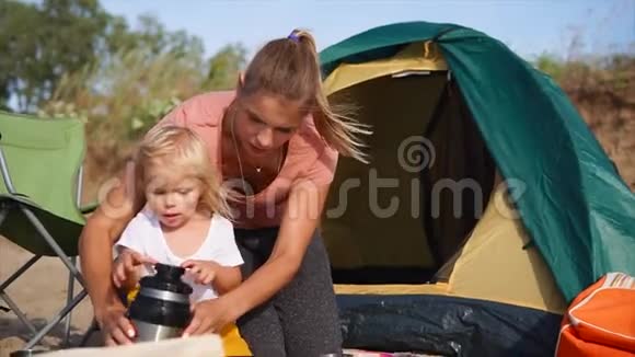 在野营期间妈妈和女儿想喝热茶取暖视频的预览图