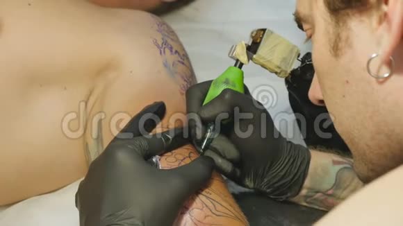 专业的纹身师在男人手做纹身视频的预览图