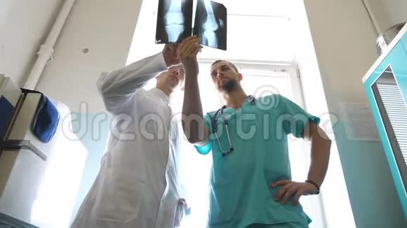 两位白种人医生观看核磁共振成像并讨论了这个问题医务人员在医院检查x射线指纹男性视频的预览图