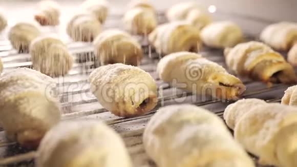 面包师把糖粉撒在黄油饼干上新鲜牛角面包上面有面粉视频的预览图