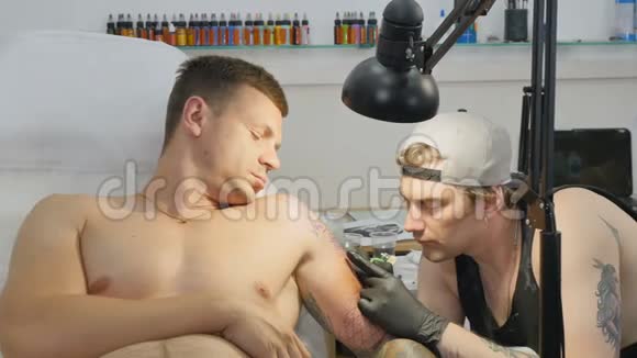 专业纹身师在纹身沙龙里人手上做纹身视频的预览图
