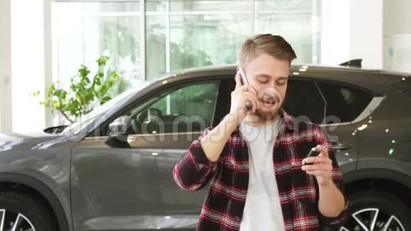 在商店买了一辆新车后一个快乐的年轻人在打电话视频的预览图