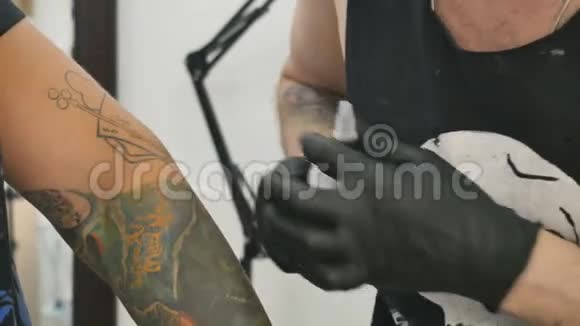 纹身师用乳胶手套摸男人手上旧纹身视频的预览图