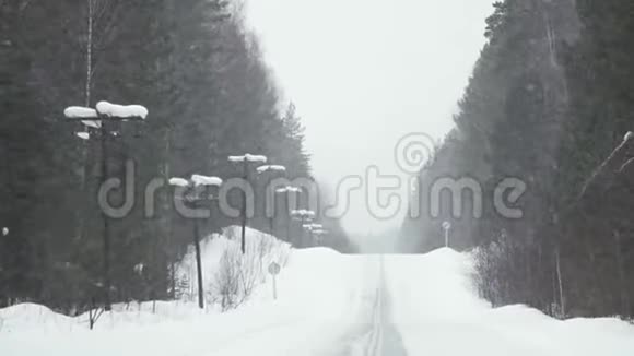 在冬季的森林道路上行驶慢动作视频的预览图