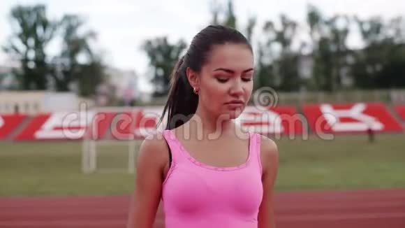 一个穿着粉红色T恤的女孩在跑步前热身视频的预览图