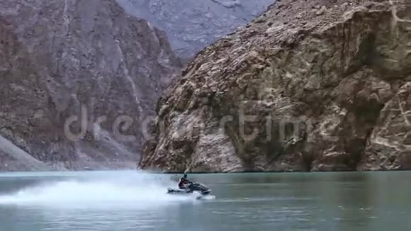 巴基斯坦吉尔吉特亨扎河谷美丽的阿塔巴德湖骑喷气式滑雪板的男子视频的预览图