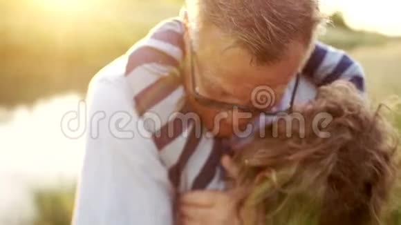 祖父拥抱并亲吻他的孙子他把它抱在怀里紧紧地抱着它两代人视频的预览图