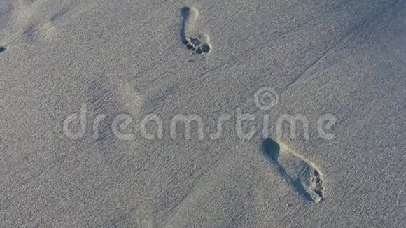 沙滩上光着脚的痕迹被海浪冲走了视频的预览图