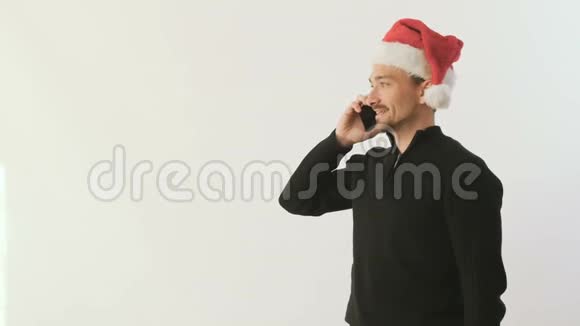 戴着圣诞老人帽子的人电话交谈手里拿着一件白色背景的礼物视频的预览图