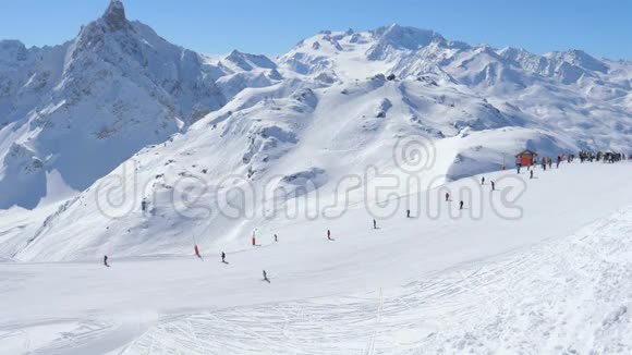 典型的晴天在一个滑雪场的山上许多滑雪者在斜坡上视频的预览图