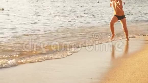 快乐的孩子正在日落的海滩上奔跑扬起飞溅慢动作视频的预览图