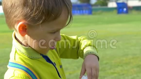 一个小男孩在绿色草坪上缓慢的特写镜头吹肥皂泡快乐的童年视频的预览图