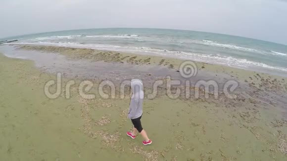 年轻的女性在海滩上散步思考生活空中无人机射击视频的预览图