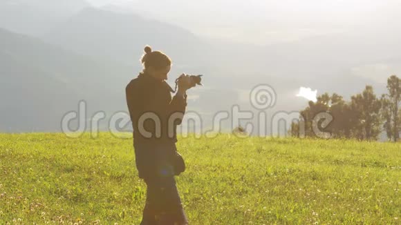 年轻女子为奥地利阿尔卑斯山脉景观拍照视频的预览图