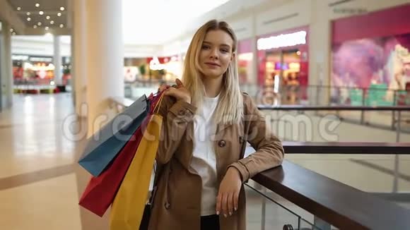 迷人的女人把购物袋放在肩上站在商场里视频的预览图
