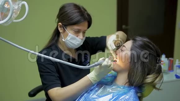 女医生口腔医生在医疗牙科诊所为年轻女性患者治疗和美白牙齿视频的预览图