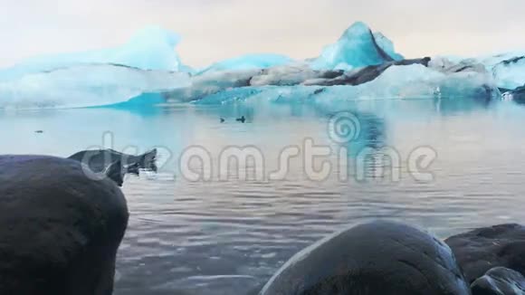 冰岛Jokulsarlon冰川泻湖流水中的蓝色冰山视频的预览图