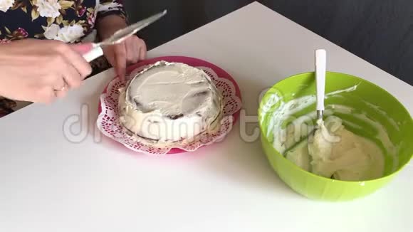 女人用奶油涂抹海绵蛋糕四面抹一层奶油视频的预览图