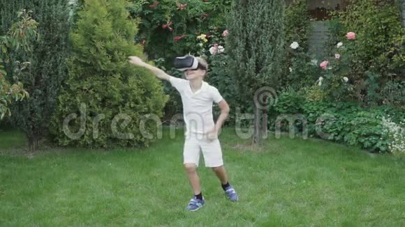 小男孩在花园里用虚拟现实眼镜视频的预览图