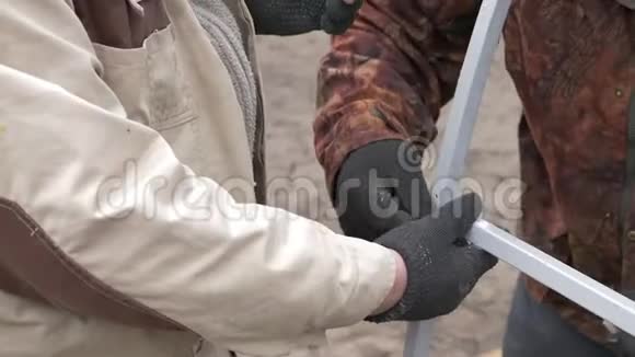 工人戴手套拧紧施工框架的螺栓视频的预览图