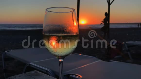 带酒的酒杯映衬着少女的轮廓和夕阳视频的预览图