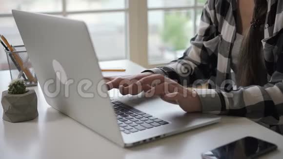 年轻女子打字看着家里桌子上的监控屏幕视频的预览图