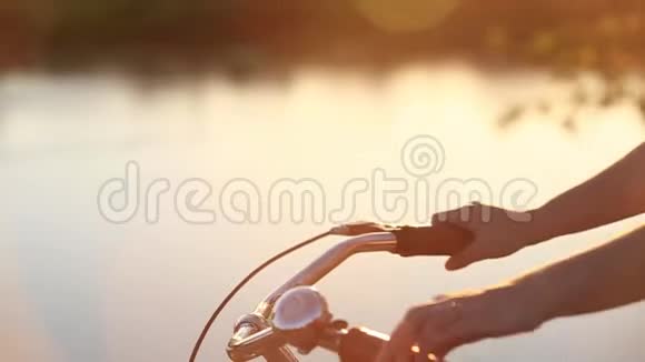 日落时在河的背景上骑自行车视频的预览图