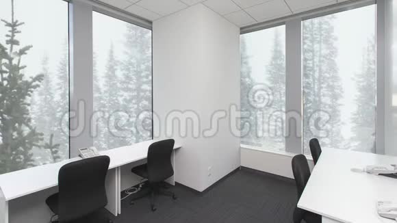 空荡荡的办公室桌子上有椅子和电话窗外的森林里下着雪背景板色度键视频的预览图