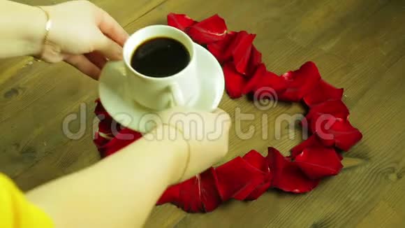 女孩在玫瑰花瓣中间放了一杯咖啡视频的预览图