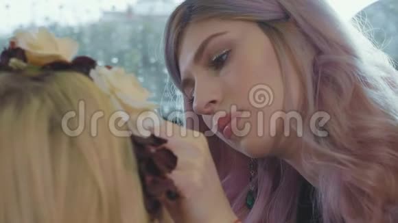 年轻的化妆师在模特脸上涂化妆品视频的预览图