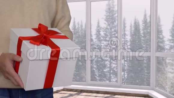 圣诞或新年礼物盒配有红丝带窗外下雪视频的预览图