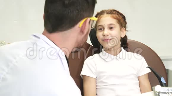 一个善良的医生检查一个小女孩的牙齿视频的预览图