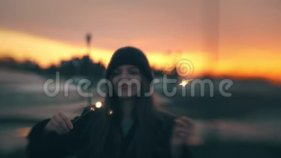 快乐的年轻女子在美丽的夕阳下与星辉嬉戏视频的预览图