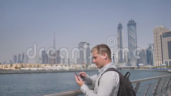 这个人拨了电话号码在迪拜全景的背景上交谈手特写视频的预览图