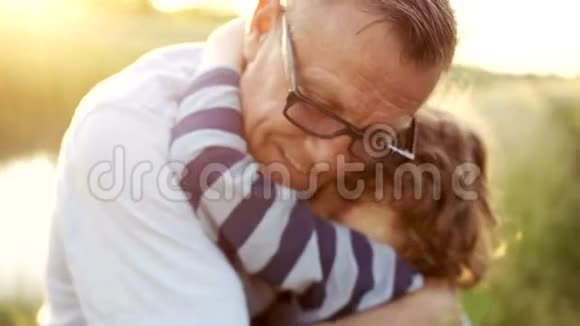 一个成熟的男人拥抱他已故的儿子的特写肖像快乐的父亲可爱的孩子戴着眼镜的男人视频的预览图