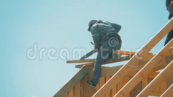 木匠盖房子屋顶用电锯看到了树木匠建造概念生活方式视频的预览图