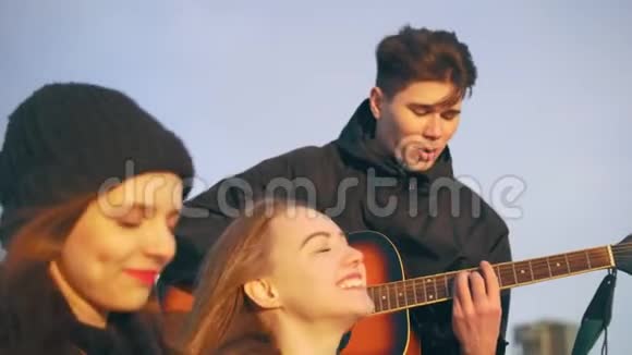 一群朋友在日落时分和吉他一起唱歌视频的预览图