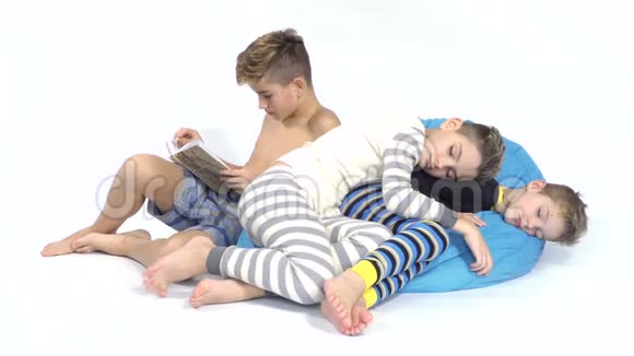 三个兄弟在白色背景下睡在豆袋上视频的预览图