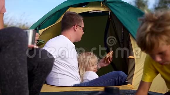 父亲正在和女儿吃午饭他们在帐篷里视频的预览图