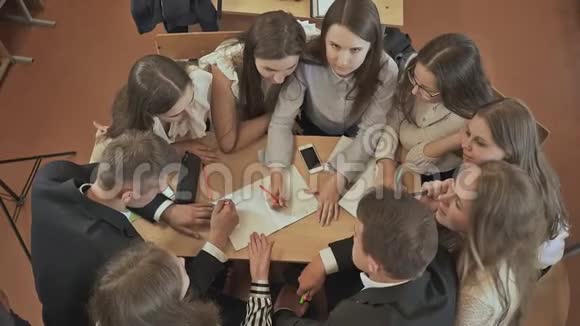 同学们围坐在桌子旁讨论学校的任务然后挥手俄罗斯学校视频的预览图
