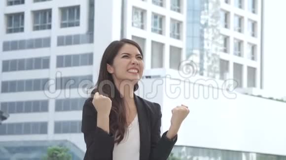 商务女性站在户外以愉快的情绪感受自信和成功视频的预览图