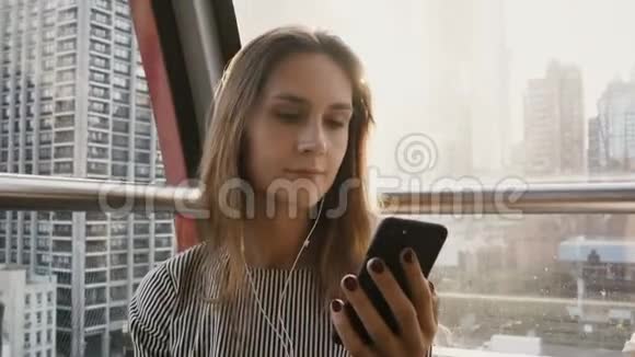 4纽约航空电车上的欧洲女孩肖像曼哈顿有智能手机和耳机的漂亮女士视频的预览图